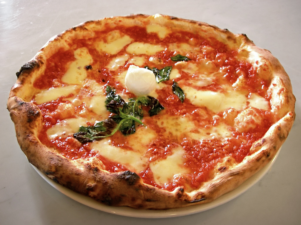 A tomato-and-basil pizza on a wooden peel